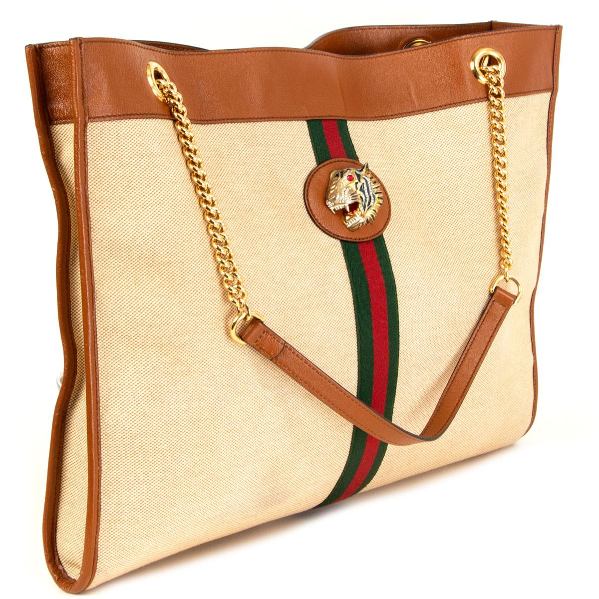 100% authentic Gucci Rajah Large tote bag in beige canvas, trimmed with cognac leather and the House Web in red and green. The line is defined by the tiger head, finished with colored enamel and sparkling crystals, inspired by a vintage piece from