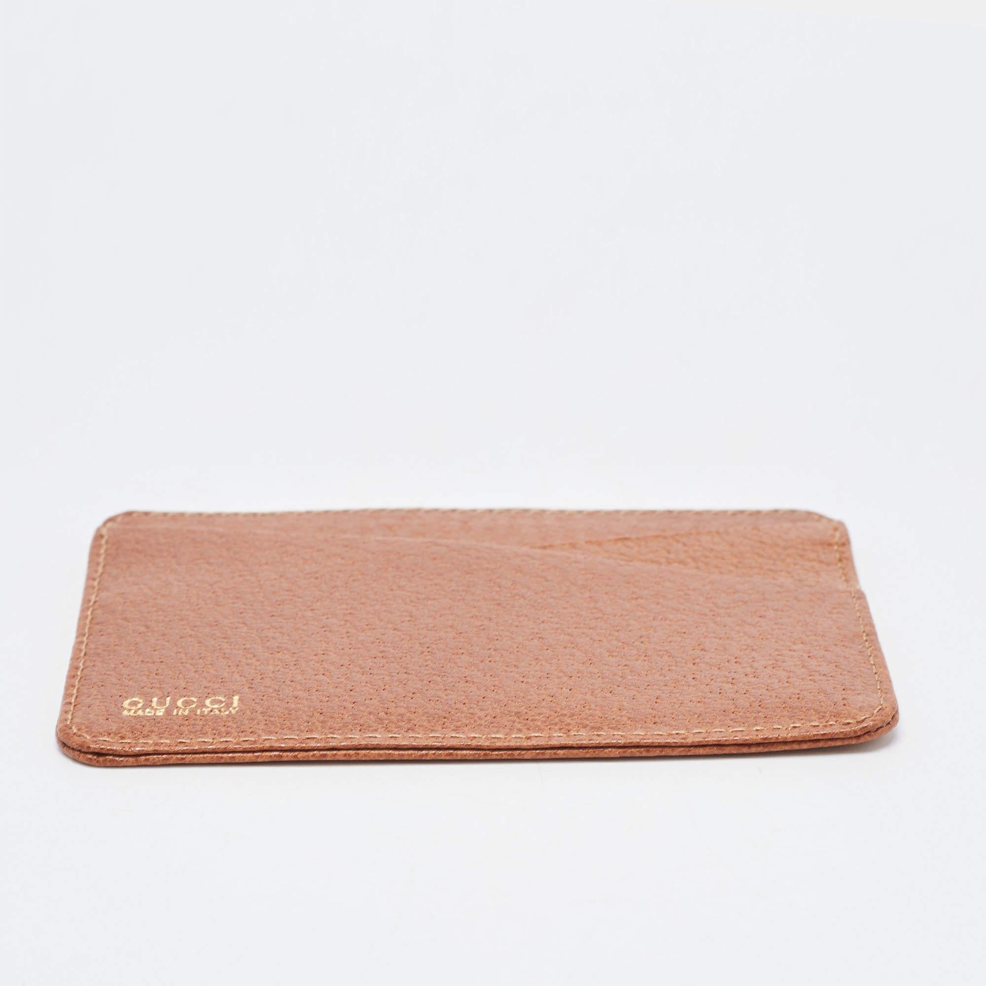 The Gucci cardholder combines elegance and functionality in a sleek design. Crafted from leather, it features a brown shade and the brand name on the front.

