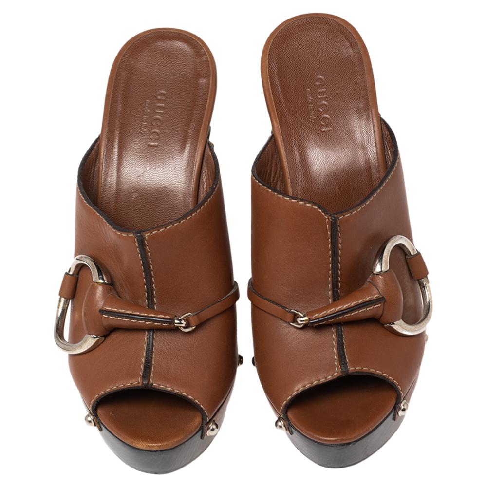 These clog slides from Gucci are crafted from leather and feature the well-known Horsebit detail on the vamp straps. They are elevated on platforms and heels and are endowed with comfortable insoles.

