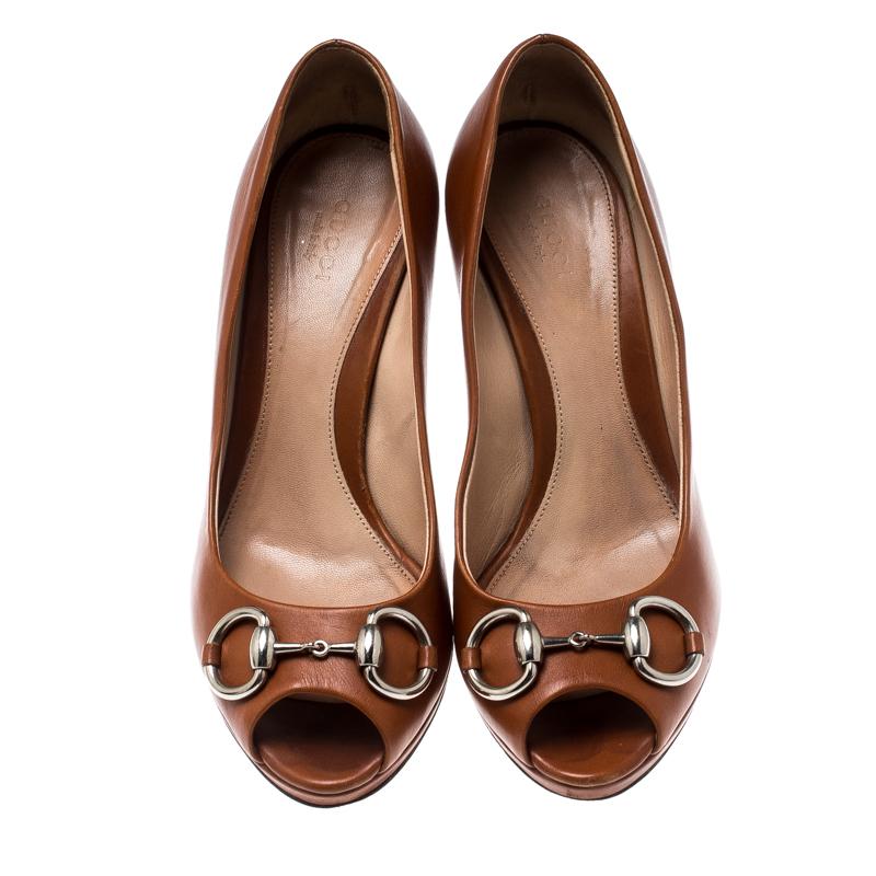 Featuring a chic, minimalist design, these pumps from Gucci are easy to style. Brown leather body showcases silver-tone signature Gucci horsebit accents on the vamps. High stiletto heels and peep toes form a distinctive outline. Their simple design