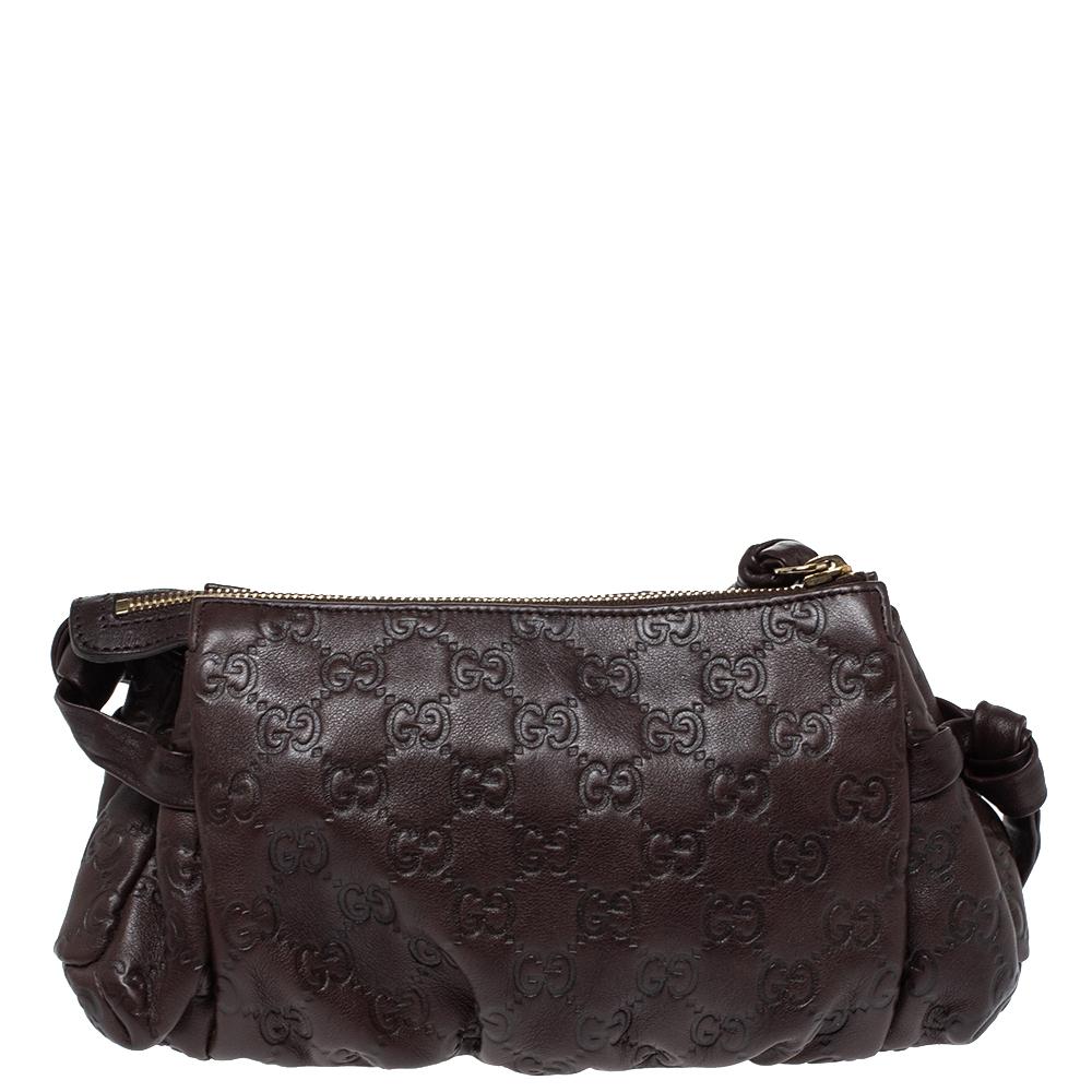 This Gucci clutch is built to suit your stylish ensembles. Crafted from leather, it has a brown shade and a zipper that secures a fabric interior. The clutch is complete with the signature Hysteria emblem on the front and a wristlet.

