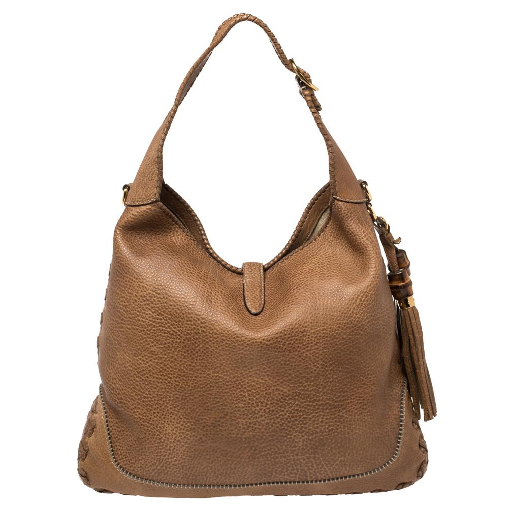 This Gucci bag will never fail you. Crafted from leather in Italy, this gorgeous number has the signature closure in gold-tone metal that opens up to a spacious canvas interior. Complete with a single handle and bamboo-detailed tassels to the side,