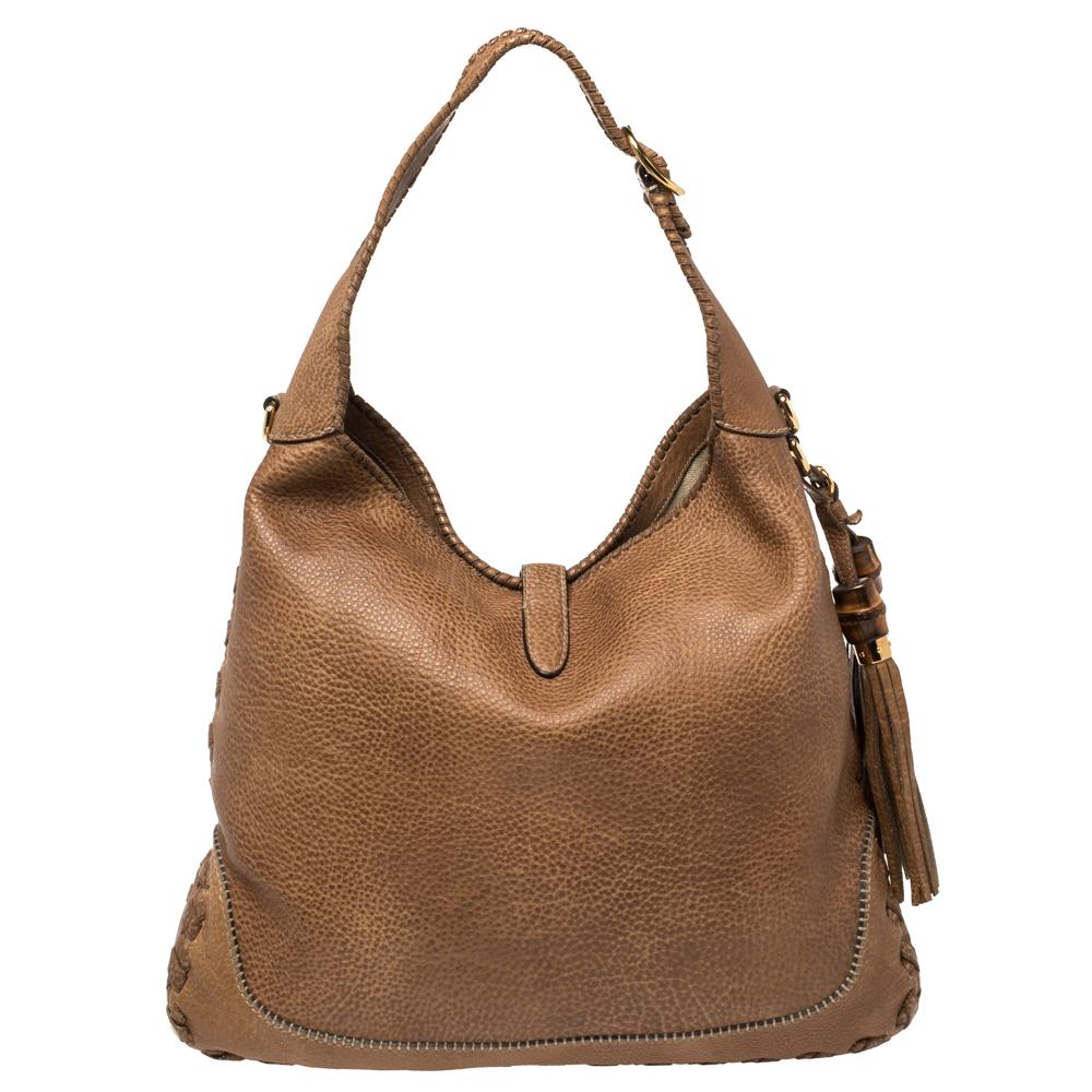 Diese Gucci-Tasche wird Sie nie im Stich lassen. Diese wunderschöne Tasche wurde in Italien aus Leder gefertigt und hat einen charakteristischen Verschluss aus goldfarbenem Metall, der ein geräumiges Innenleben aus Canvas bietet. Mit einem einzigen