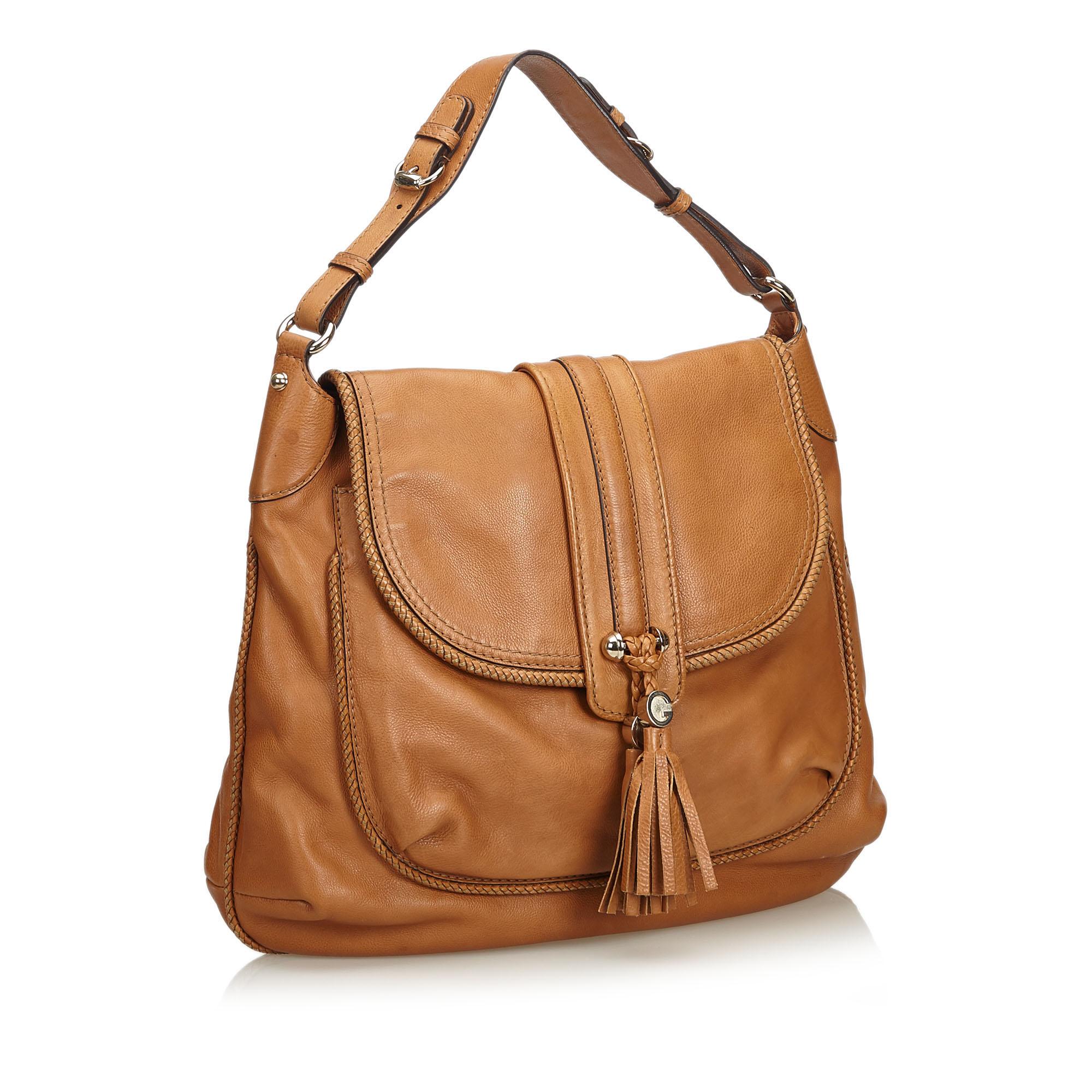 This shoulder bag features a leather body, a front exterior slip pocket, a flat leather strap, a front flap with tassel details, an open top, and interior zip pockets. It carries as B+ condition rating.

Inclusions: 
Dust Bag

Dimensions:
Length: