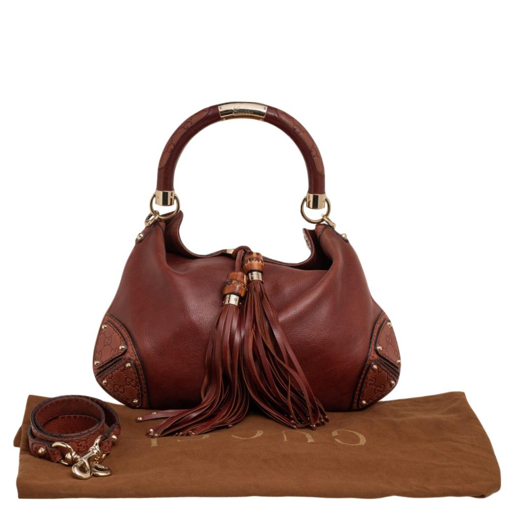 This Babouska Indy hobo is an iconic and beloved creation from Gucci. It is crafted using brown leather with two tassels motifs hanging from the front, decorative armored corners, and gold-tone hardware. Lined with fabric on the interior, this hobo