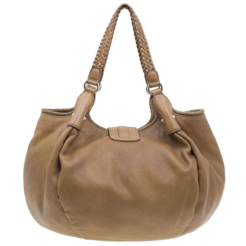 Let comfort be accompanied by style with this splendid Marrakech medium hobo by Gucci. Crafted in leather in beautiful brown, the long tassels with G charms look simply splendid in the front. The exterior exhibits double hand braided handles,