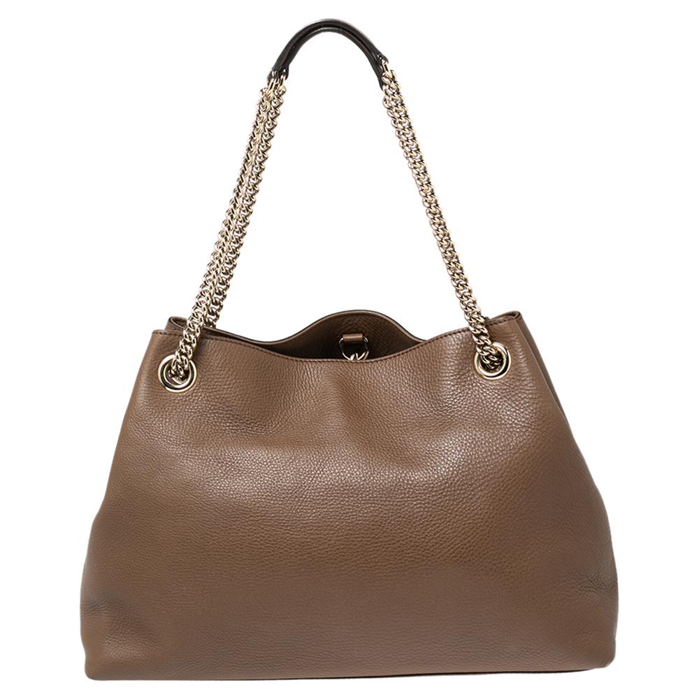 Realizzata in Italia, questa borsa Soho di Gucci è stata realizzata in pelle, foderata in tela all'interno e dimensionata per contenere i tuoi oggetti essenziali. È dotata di finiture dorate, due manici a catena, un elegante accento di nappe e la