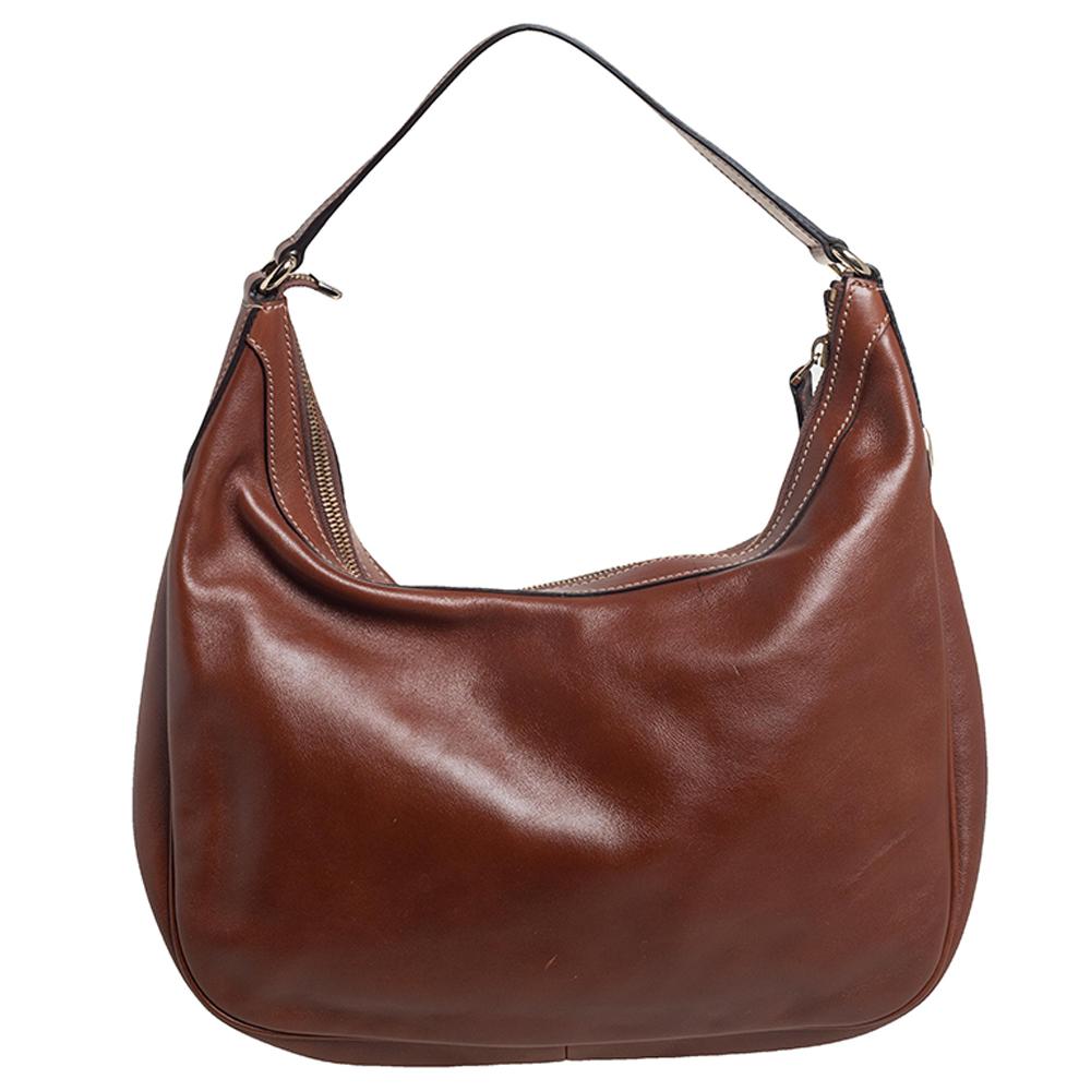 This Gucci hobo is built for everyday use. Crafted from leather, it has a lovely shape and a single handle for you to parade it. The fabric-lined interior is spacious and this brown Charmy hobo is complete with a top zip closure.

