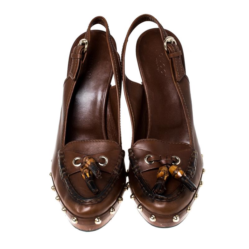 Add some elegant and feminine style with a unique touch to your day time wear collection with these Gucci clogs. Constructed in brown leather with tassels on the vamps, wooden platforms and high heels, these shoes are completed with gold-tone studs