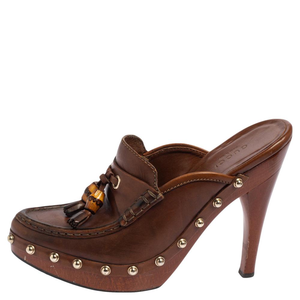 Embrace comfortable style with these clogs from Gucci! They carry a brown exterior made from leather and are designed with bamboo tassels on the uppers. They are complete with platforms and 13 cm heels.

Includes: Original Dustbag