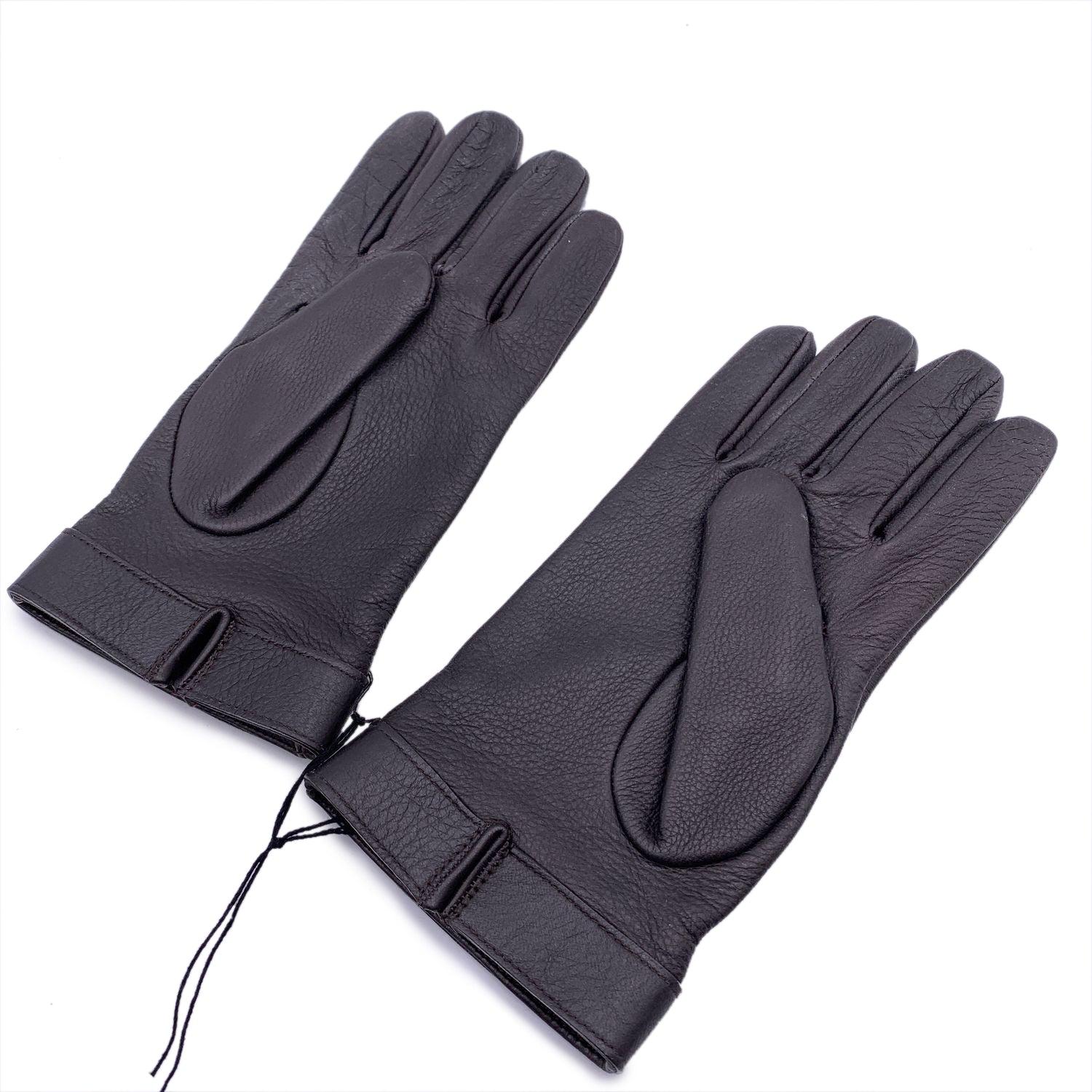 Elegant Gloves by Gucci. Dark brown leather with GG Gold and silver metal logo detail. Composition: 100% leather. Lining: 100% cashmere. Size 9 L Details MATERIAL: Leather COLOR: Brown MODEL: - GENDER: Unisex Adults COUNTRY OF MANUFACTURE: Italy