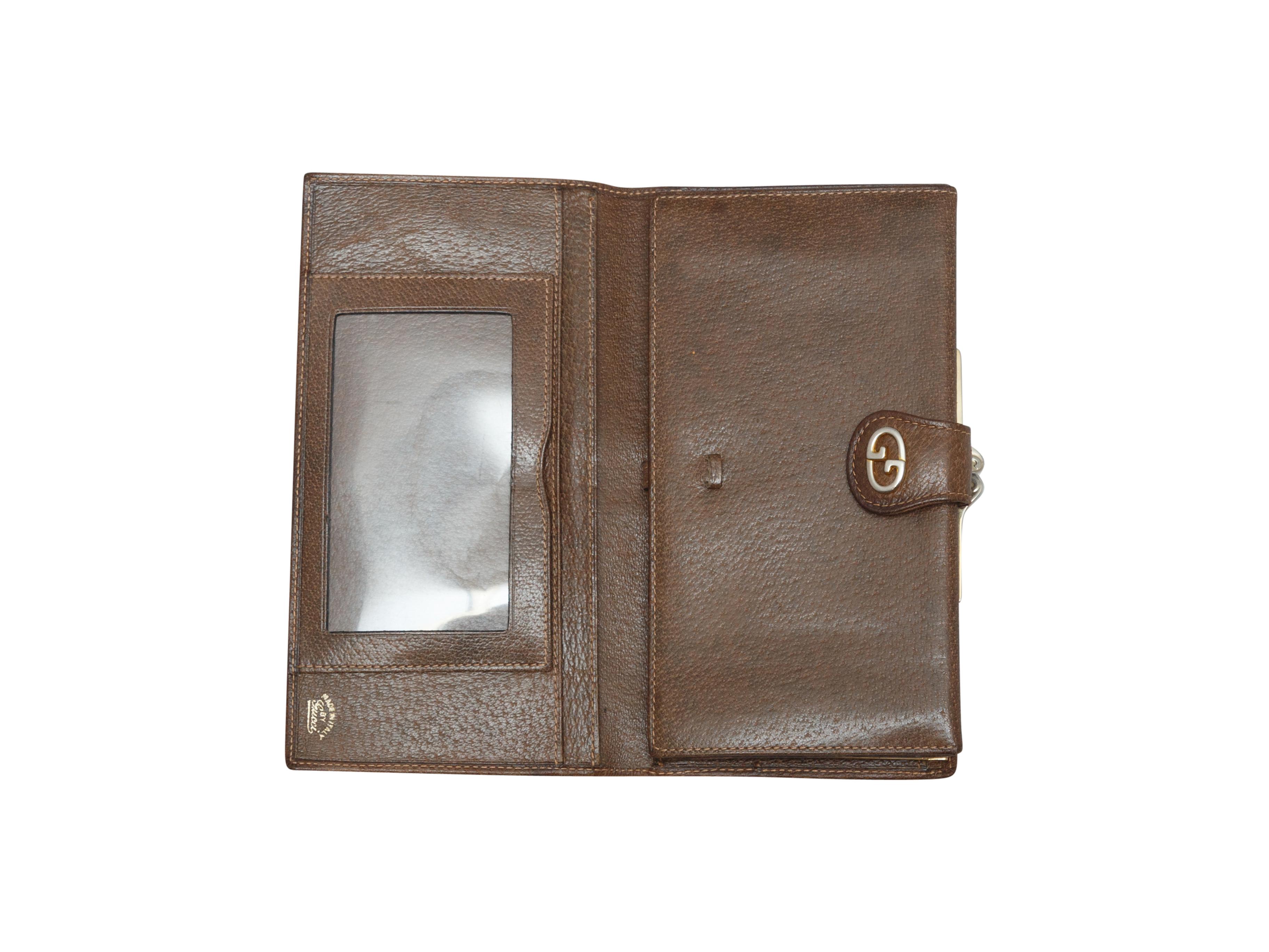 Product details: Vintage brown leather wallet by Gucci. Gucci Web accent strip at center. GG snap closure at front. Interior coin pouch, money and card slots. 7.63