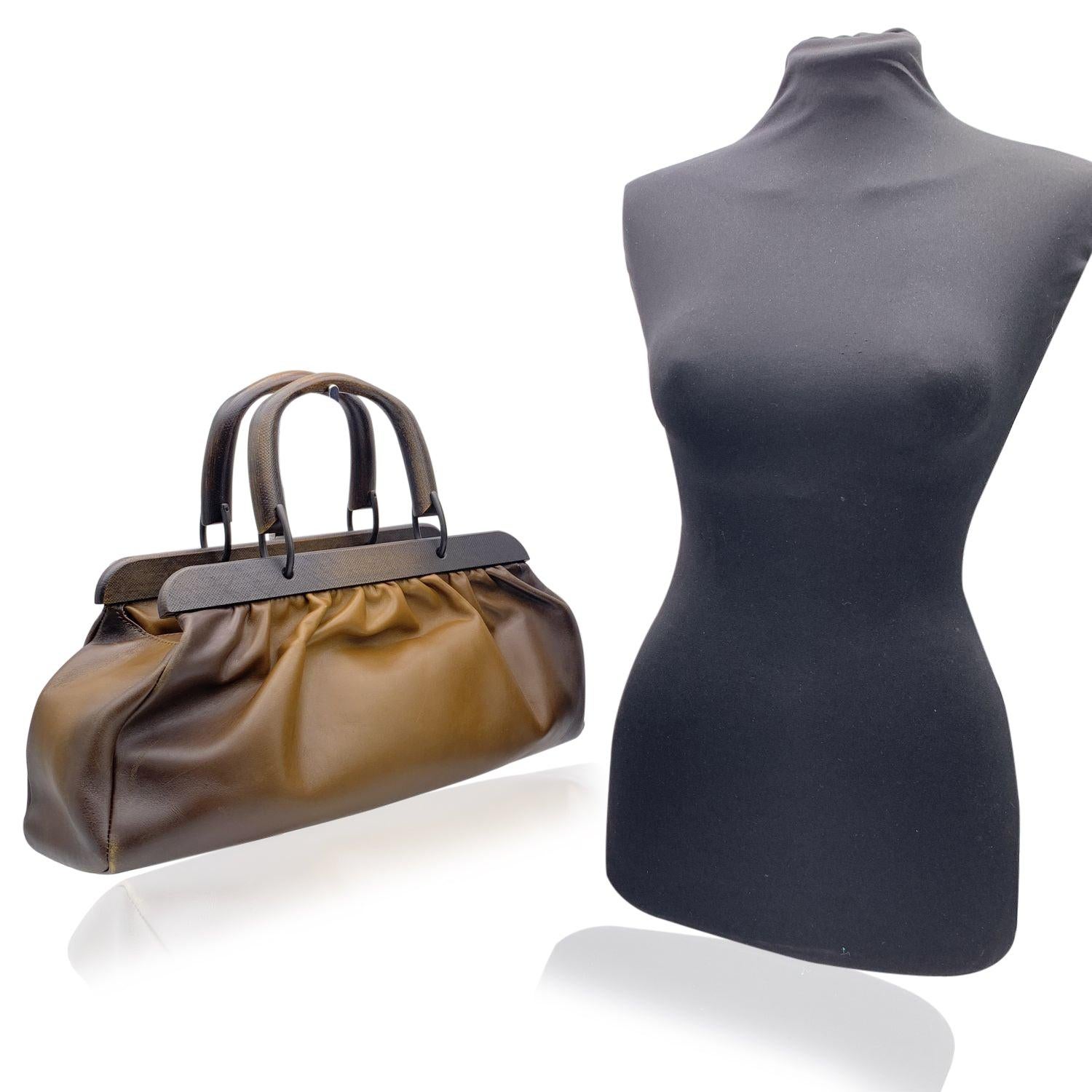 Beautiful Gucci handbag in brown ombrè leather. The bag is from the Tom Ford Era. It features wood frame and handles. Straps with buckle closure on top. Brown canvas lining. 1 side zip pocket inside. 'Gucci - Made in Italy' tag inside (serial number