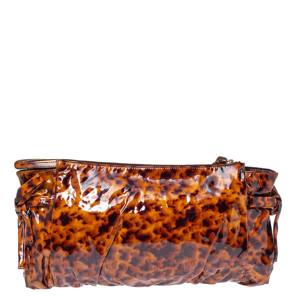 This Gucci Hysteria clutch is built to suit your stylish ensembles. Crafted from leopard-print patent leather, it has a brown shade and a zipper which secures a nylon interior. The clutch is complete with the signature Hysteria emblem on the front