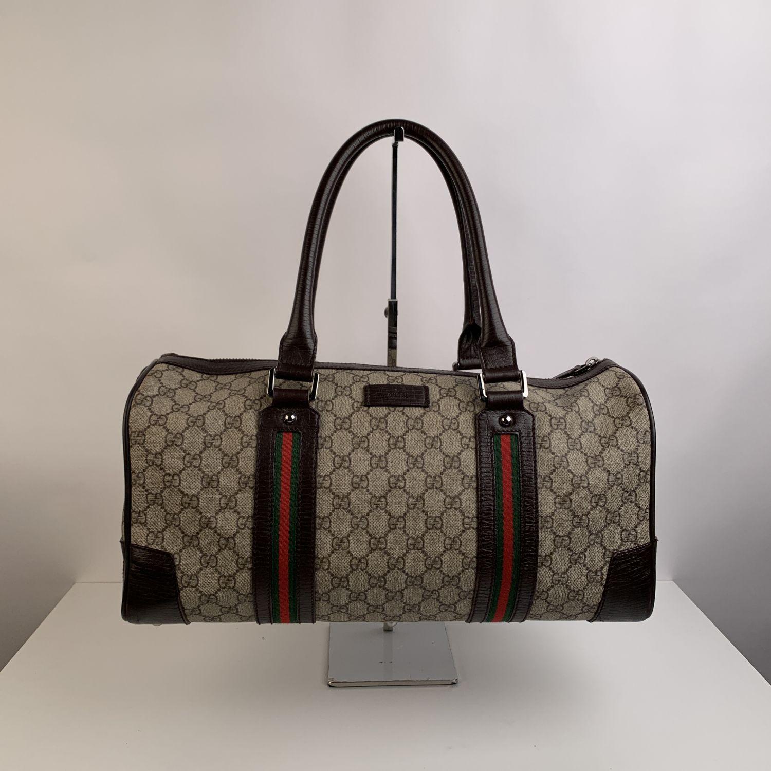 Gucci Web Carry On Duffle top handle Boston Bag. The bag is crafted in Gucci GG monogram canvas with dark brown leather trim. It features double green/red/green signature Web stripes and silver metal hardware. Fabric lining. Interior zip pocket.