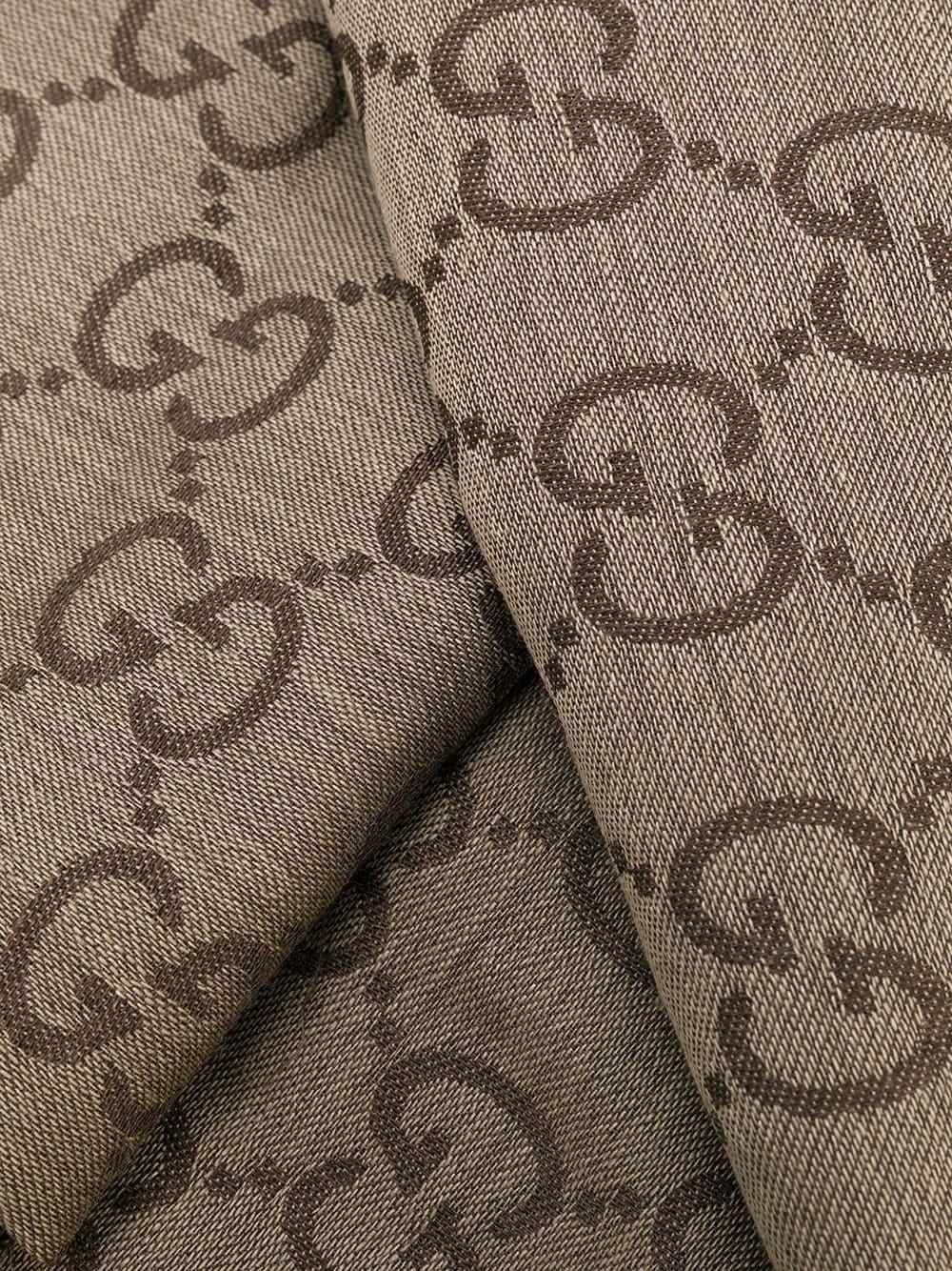 Crafted in Italy from an intricate blend of wool and silk in a neutral palette of brown and taupe, this monogram print scarf from Gucci features an all-over GG Jacquard print design and fringed edges.

Colour: Brown/ Taupe

Composition: 70% Wool,