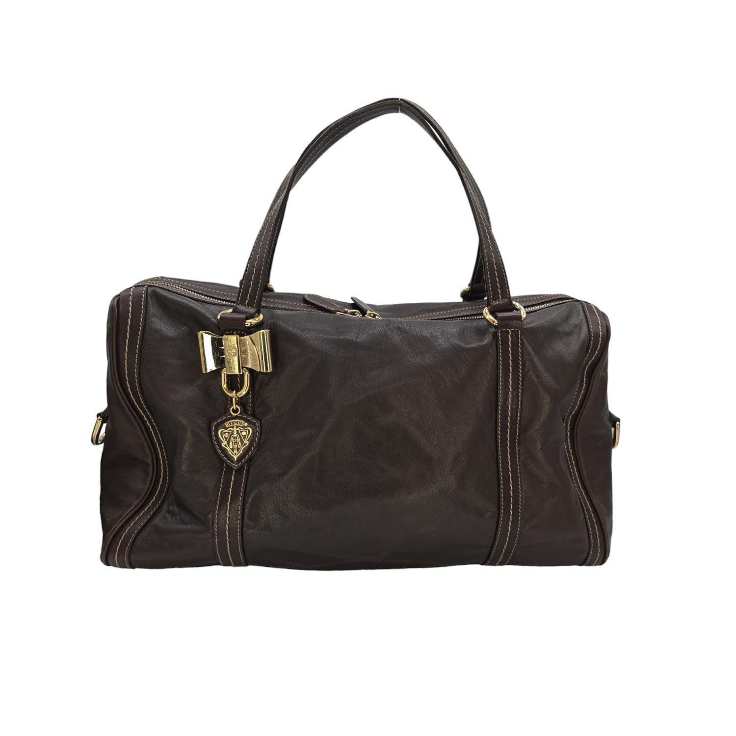 Indulge in luxury with the Gucci Duchessa Boston Bag. Handcrafted from rich dark brown leather, this bag features top handles and a spacious interior with three pockets for your essentials. The polished gold-toned hardware and Gucci dust bag add a