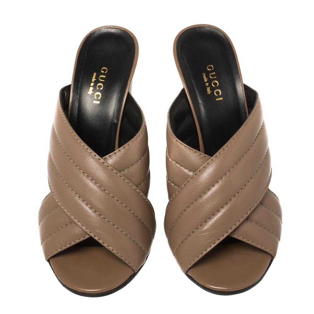 Be fashionable and comfortable in these Gucci slide sandals. Crafted from leather in brown, they come styled with quilted crossover straps and 10 cm block heels. The insoles have also been lined with leather and stamped with the brand's well-known