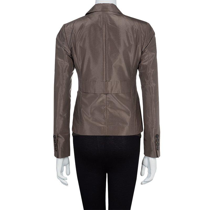 Crafted in Italy, the Gucci brown blazer is a personification of feminine delicacy in style with glamour. In a blend of silk and polyester, the jacket has notched lapels. The jacket also features two front and back darts with a back belt for fitting