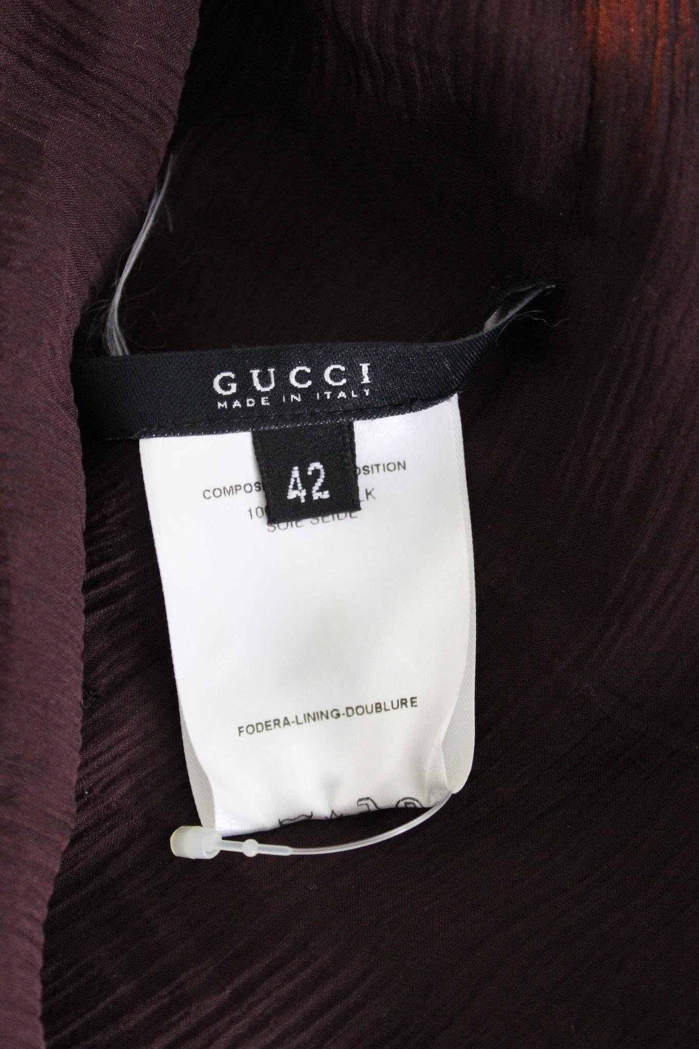 This Gucci shirt is from the 2000s and features a soft and transparent design. It is made from luxurious silk, which adds to its comfort and quality. The shirt comes in a brown color and features a v-neckline, making it a stylish and versatile