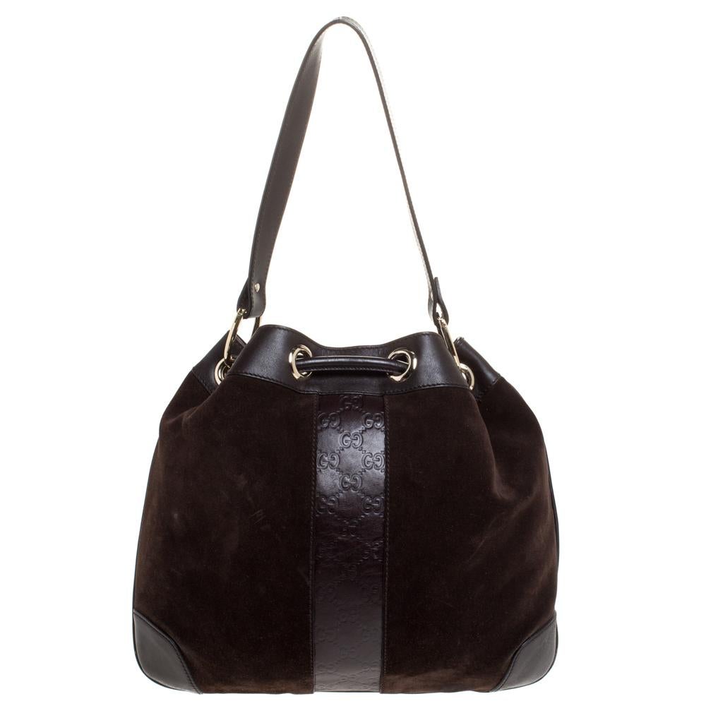 This brown Gucci hobo promises to take you from day to night and weekday to weekend. This suede and leather bag is artistically designed to reflect your style. The fabric lining and the single handle add to its design.

