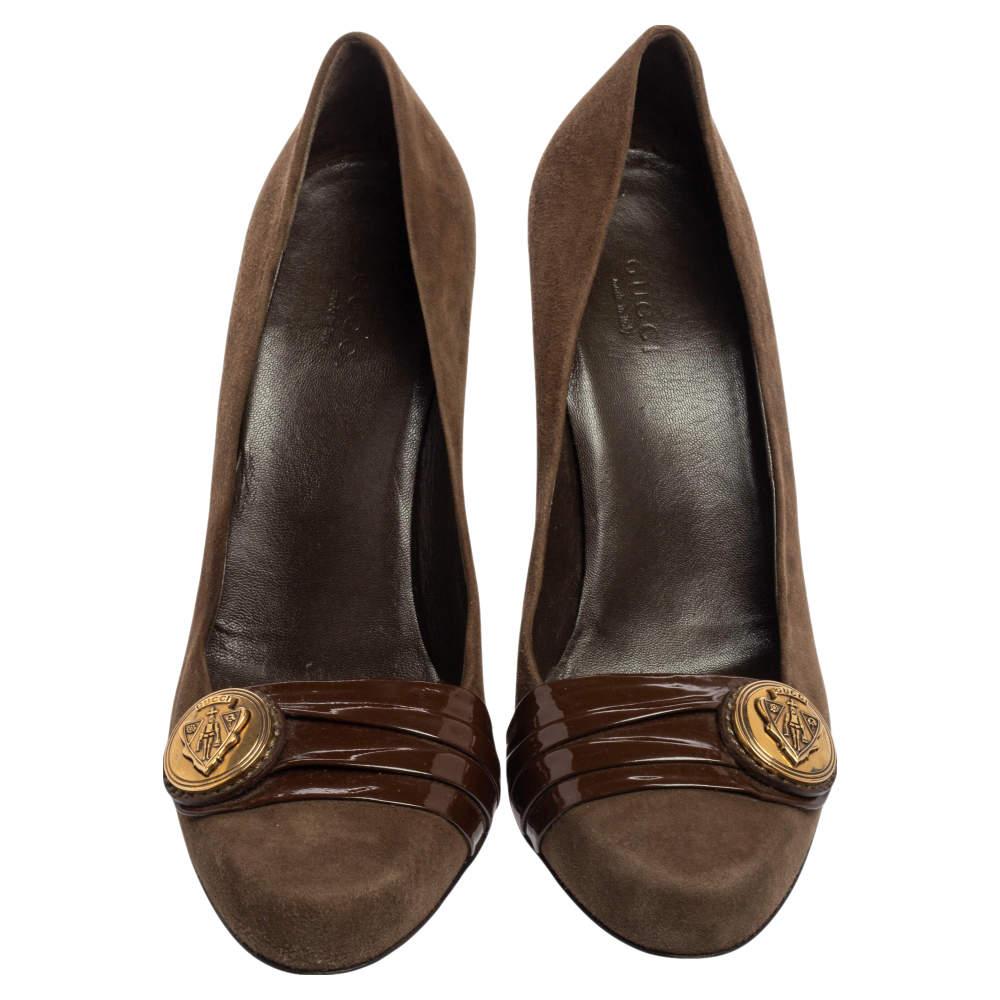 These elegant pumps by Gucci are constructed using brown suede. Covered toes, patent leather with logo buckle detailing, and 9 cm heels complete the design.

Includes: Original Dustbag

