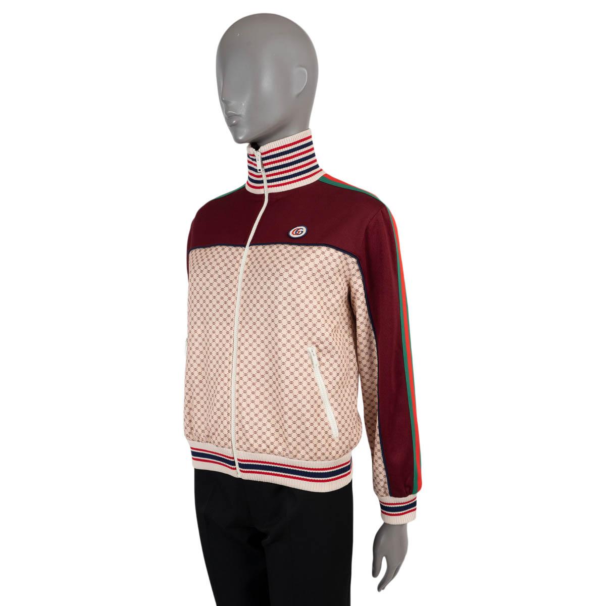 100% authentische Gucci Trainingsjacke in Burgunderrot und Beige mit Monogrammen aus Polyester (55%) und Baumwolle (45%). Mit hohem Halsausschnitt, gestreiften Rippstrickbündchen, einem GG Aufnäher und zwei Reißverschlusstaschen an der Taille.