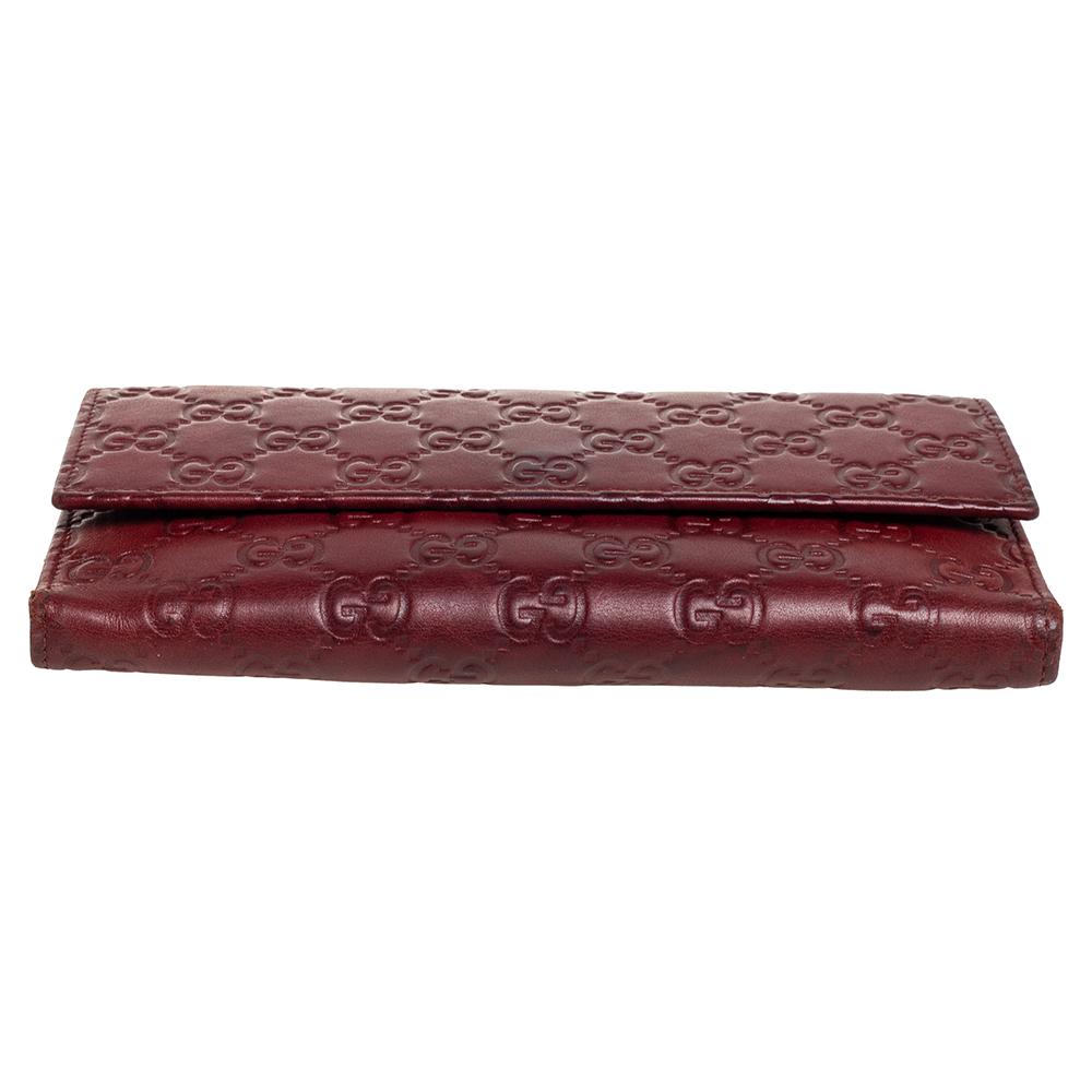 Made of signature Guccissima leather in burgundy, this continental wallet from Gucci is a classy choice. The snap button opens to multiple card slots and open compartments. This wallet is complete with gold-tone hardware.

Includes: Original Box