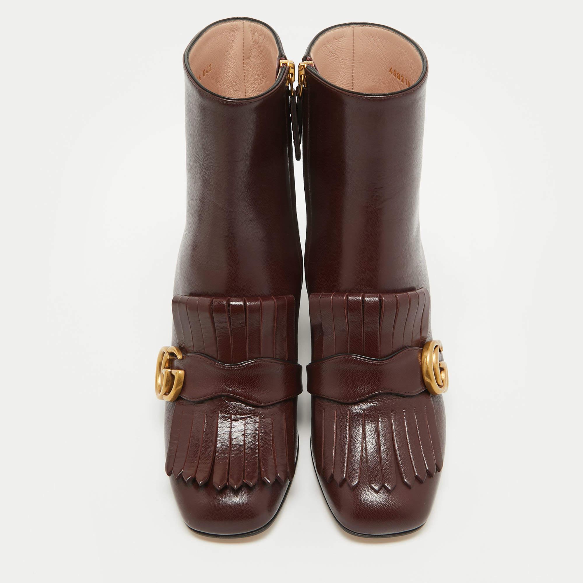 Indulge in opulent sophistication with the Gucci GG Marmont ankle boots. Crafted from luxurious leather, these boots exude timeless elegance with their signature GG motif and playful fringe detailing. Elevate any ensemble with their rich burgundy