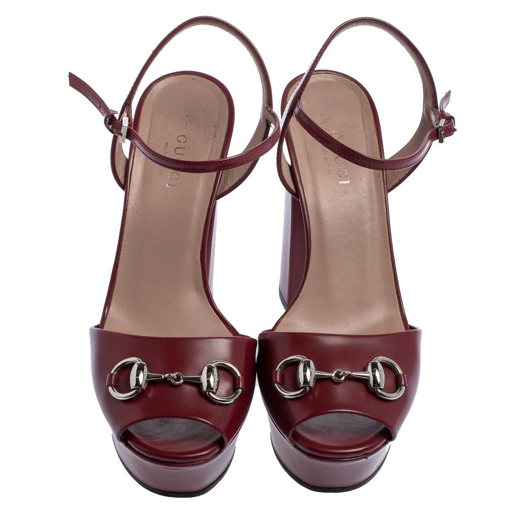 How lovely are these sandals from Gucci! They've been beautifully crafted from leather and styled with the iconic Horsebit accents on the uppers. They carry peep-toes, ankle wraps, and 12 cm block heels supported by platforms. Let this burgundy pair