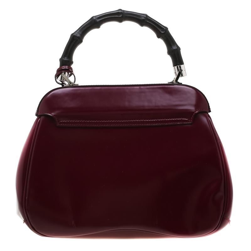Featuring the iconic Lady Lock bamboo handle bag from Gucci. This bag is crafted from burgundy leather and features a bamboo top handle. The push lock closure opens to a suede-lined interior that houses two open compartments. Carry this trendy style