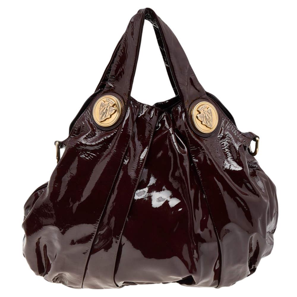 Diese Gucci Hysteria Tasche ist für den täglichen Gebrauch konzipiert. Sie ist aus weinrotem Lackleder gefertigt und verfügt über zwei Griffe, mit denen Sie sie leicht transportieren können. Das Innenleben aus Nylon ist gut bemessen und die Tasche