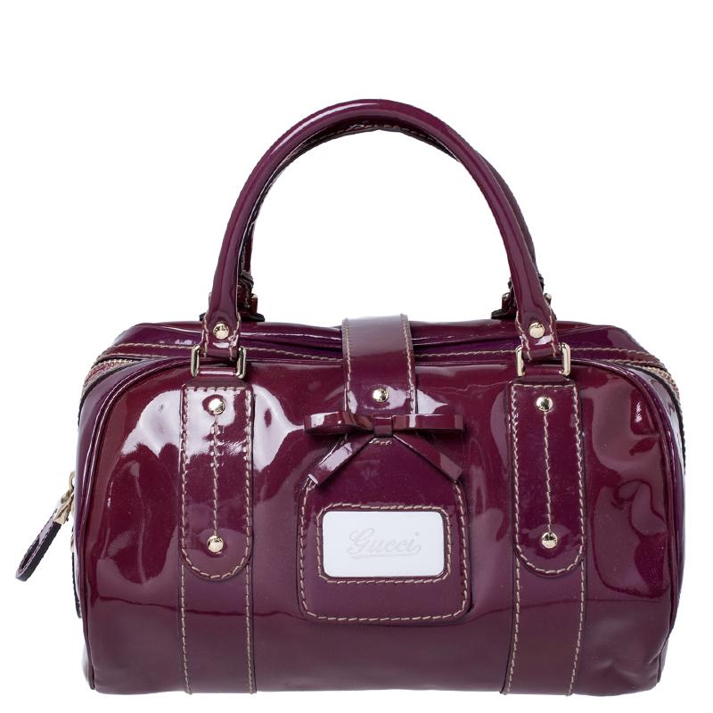 Spice up your everyday look with this gorgeously designed bag by Gucci. Crafted from patent leather, it comes in a stunning shade of burgundy. It comes equipped with dual handles, protective metal feet, and zip closure. It also features a strap with