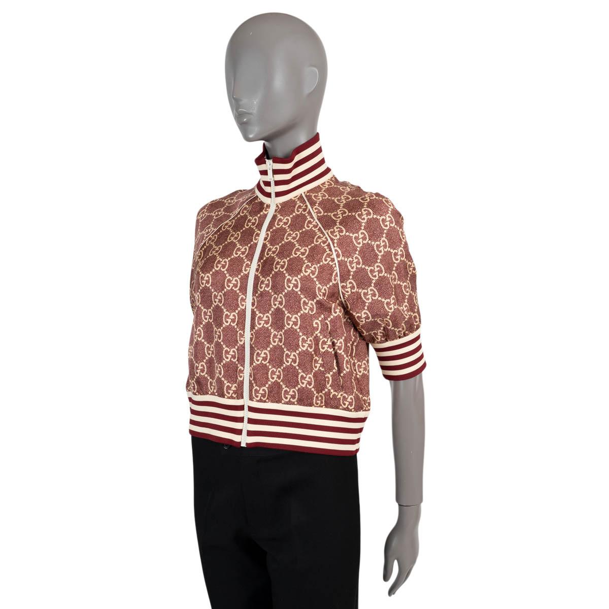 100% authentic Gucci short sleeve cropped bomber in burgundy and beige monogram silk (100%). Features a high neck, raglan sleeves (measurement taken from the neck), two slant pockets and striped elastic trims. Has been worn and is in excellent