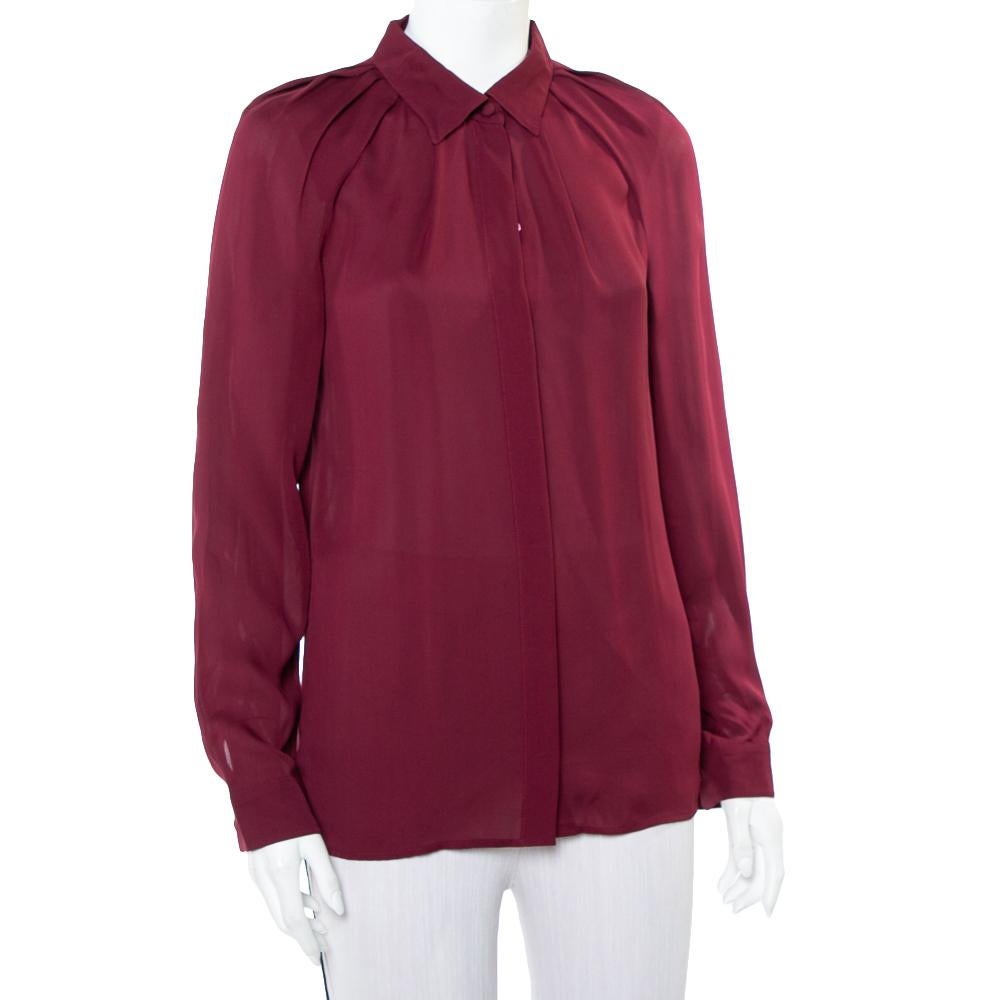 Tailored from 100% silk in a burgundy hue, this Gucci shirt for women is equal parts chic, comfortable, and sophisticated. It features a front button fastening and a classic collar around which the subtle pleated details add oodles of femininity to