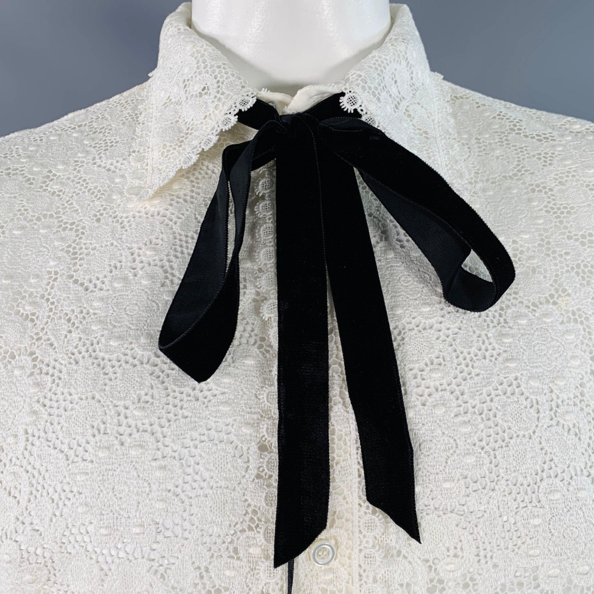 Chemise à manches longues GUCCI by ALESSANDRO MICHELE
en dentelle macramé de coton blanc mélangé, avec un motif de dentelle florale transparente, un col ouvert avec nœud papillon en velours noir et une fermeture à boutons. Fabriqué en Italie. Très
