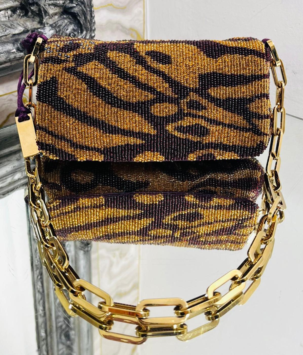 Gucci By Tom Ford Beaded Evening Bag

Very rear is this dark gold and purple bag designed with tiger inspired sparkling beaded pattern throughout.

Detailed with gold chain-link shoulder strap and front flap leading to purple silk lined