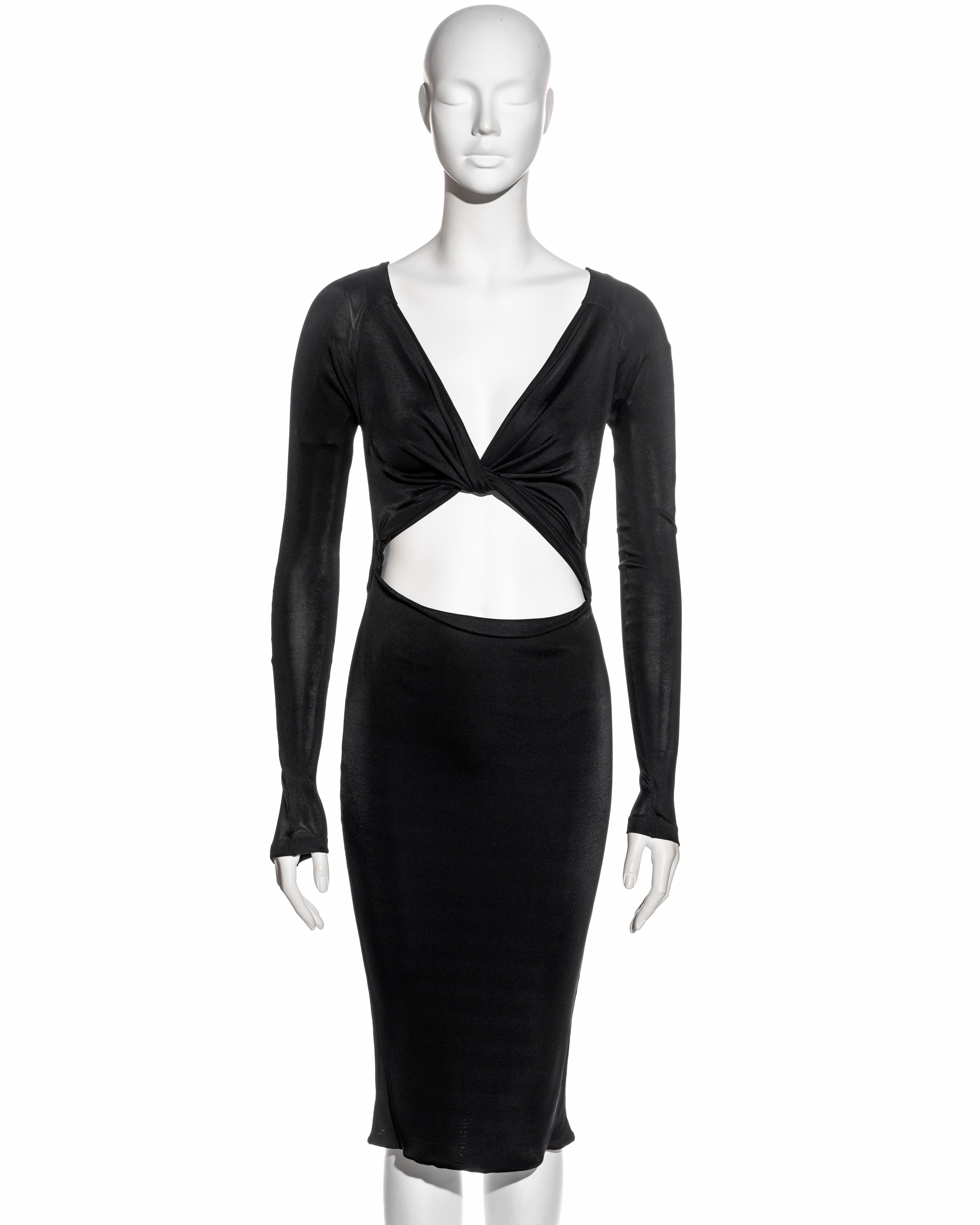 ▪ Gucci black long sleeve evening dress
▪ Designed by Tom Ford 
▪ Plunge v-neckline
▪ Knotted front
▪ Bare midriff  
▪ Open back 
▪ Four long ties fastening at the back which can be styled in various ways
▪ Size Medium
▪ Fall-Winter 2003
▪ 50%