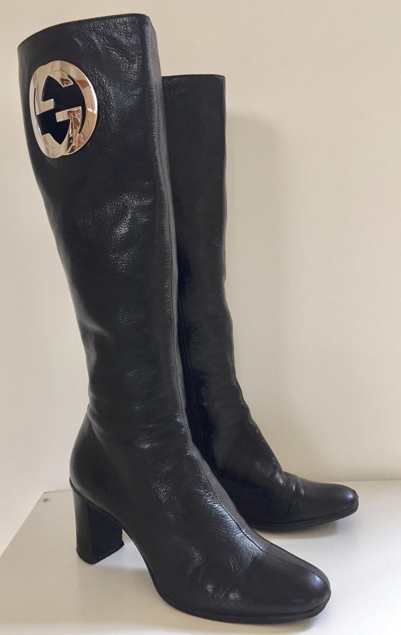Tom Ford’s Gucci pair of knee-high leather boots, circa 1999.
In a sleek silhouette, these vintage Gucci boots are crafted in black lamb supple leather, finished with a block heel, side zipper and a prominent monogram in silver tones on only one