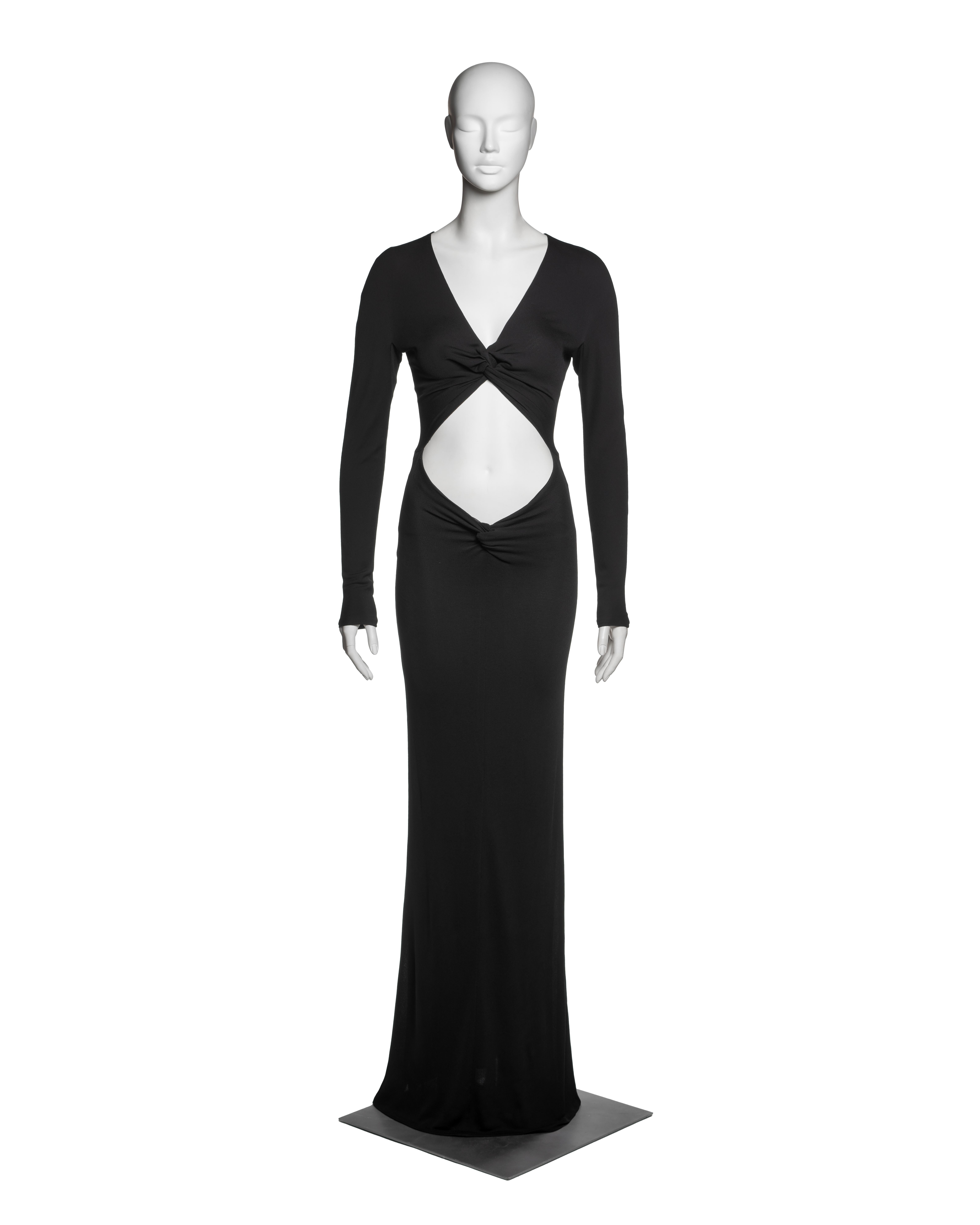 This Gucci by Tom Ford evening dress from the Fall-Winter 2002 collection is constructed in black rayon jersey with a self-lined finish, enhancing structure and opacity while maintaining fluid drape. The design features a plunging V-neckline and