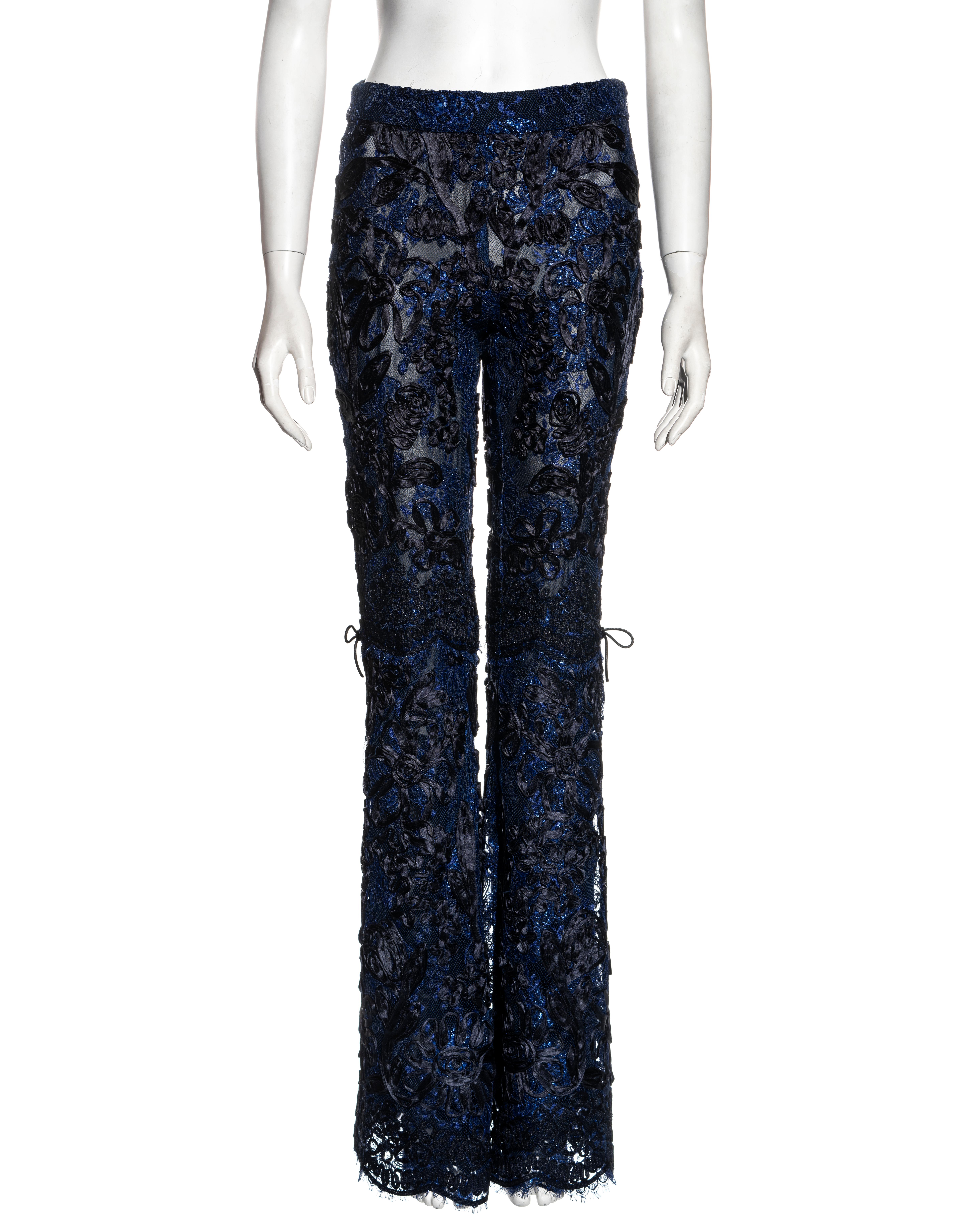 ▪ Gucci lace evening pants
▪ Designed by Tom Ford 
▪ Blue and black lamé floral lace
▪ Black ribbon embroidery
▪ Leather bows at the knees 
▪ Flared leg
▪ Silk chiffon lining 
▪ IT 40 - FR 36 - UK 8 - US 4
▪ Fall-Winter 1999
▪ 71% Rayon, 12% Cotton,
