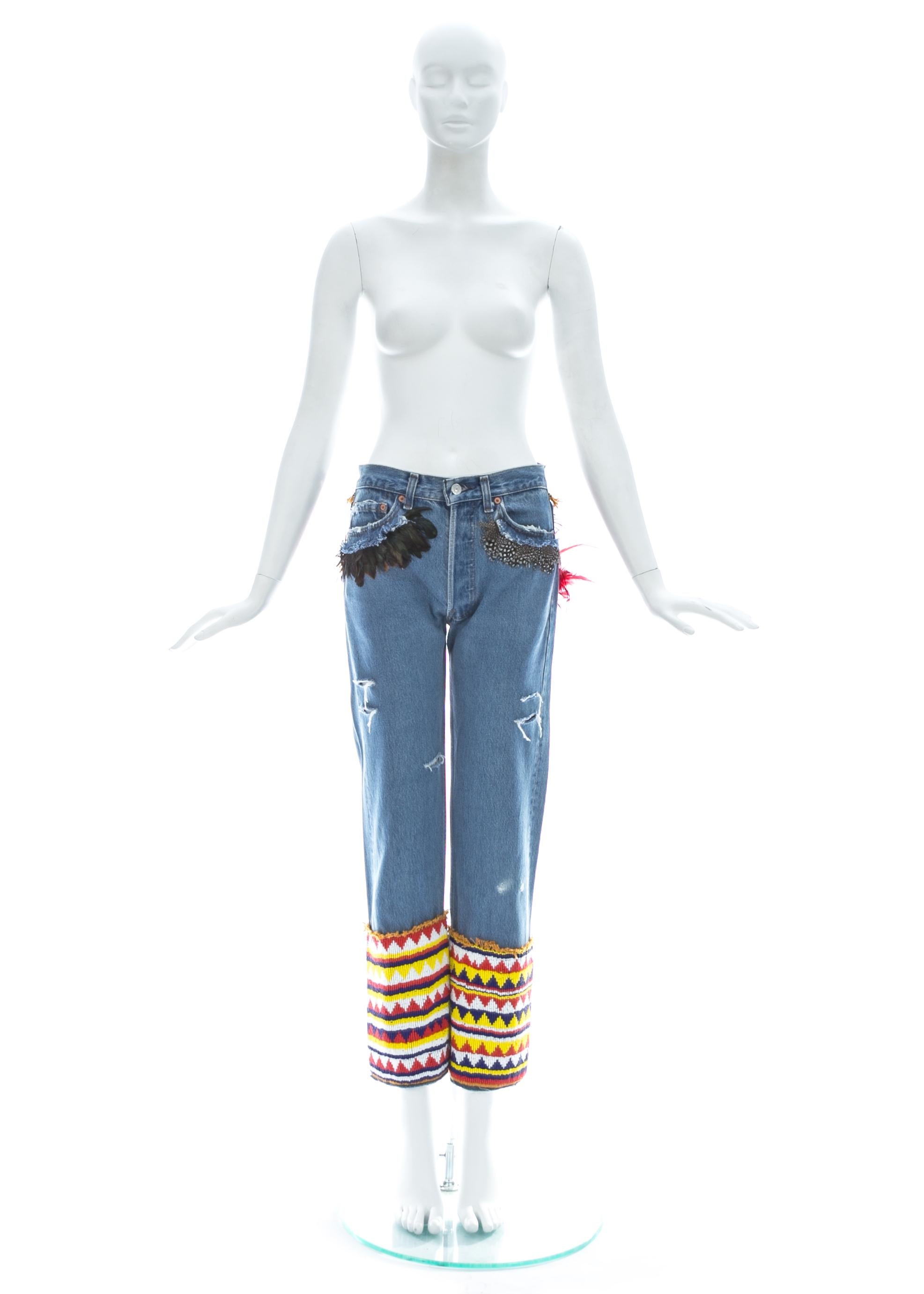 Gucci by Tom Ford; Light blue distressed denim slim-fit Levi jeans with feather trim around pockets and multicolour beading around leg opening.

Spring-Summer 1999