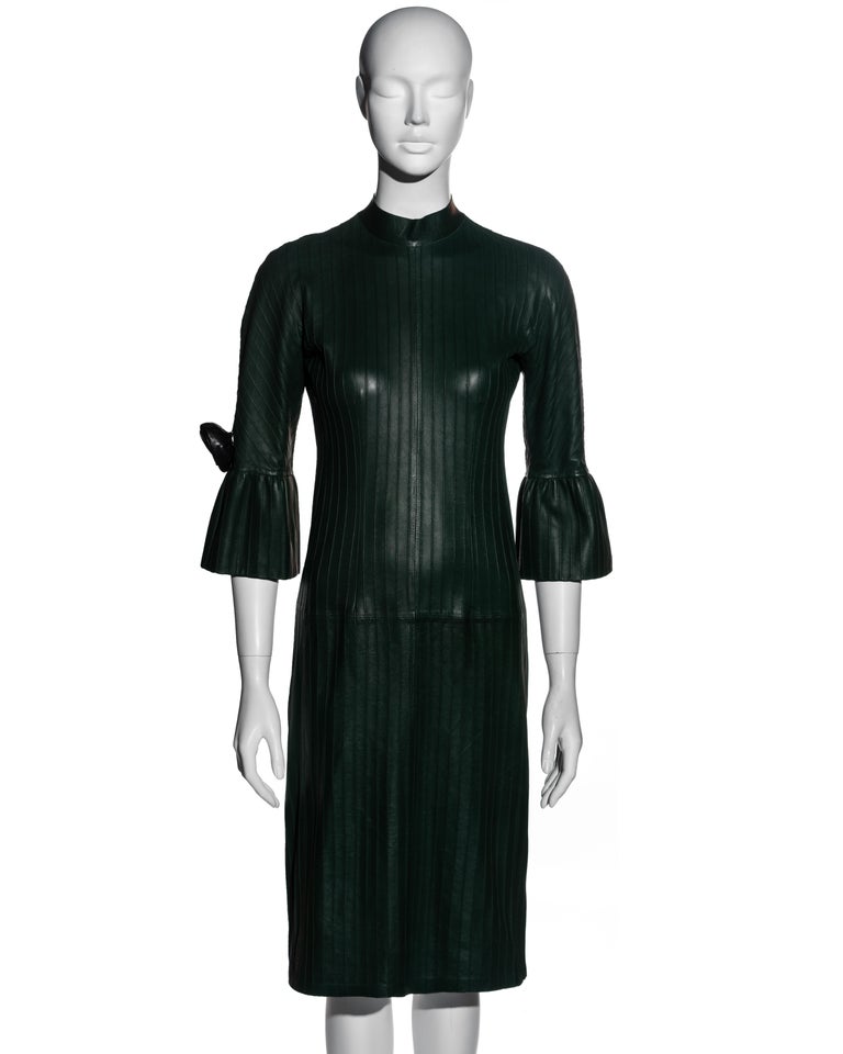▪ Gucci bottle green leather shift dress
▪ Designed by Tom Ford
▪ Pintuck detail 
▪ Three-quarter circular flounce sleeves 
▪ Black leather rosette on sleeve 
▪ Zipper at centre back 
▪ IT 40 - FR 36 - UK 8 - US 4
▪ Fall-Winter 1999
