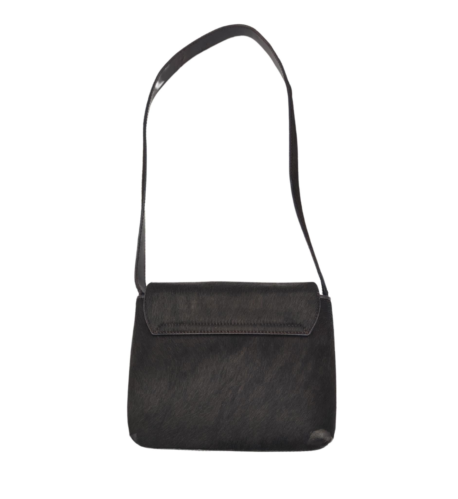 Gucci by Tom Ford F/W 1996 shoulder bag
Brown pony hair
Golden metal logo

Measurements: 
18x15x6 cm
strap drop 30 cm
7x6x2.5 in
strap drop 12 in

Good condition
Various signs of age and use