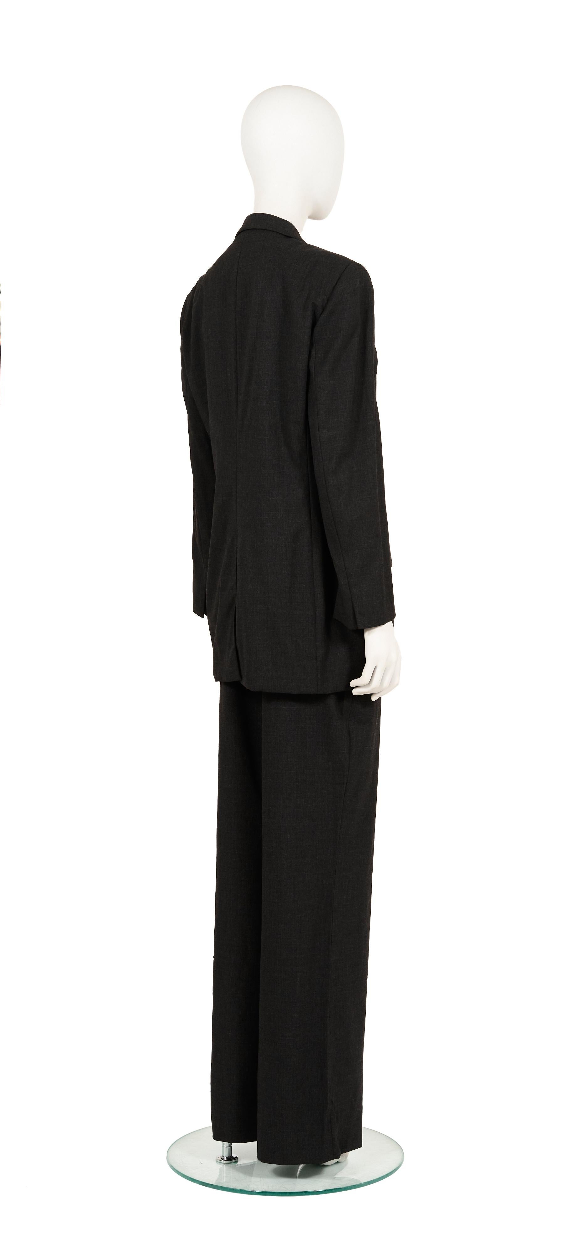 - Gucci von Tom Ford
- Verkauft von Gold Palms Vintage 
- Herbst-Winter-Kollektion 1997
- Dunkelgrauer Anzug (Blazer + Hose) 
- Übergrößen-Passform 
- Unsichtbare Knöpfe innen (Jacke)
- Weite Hosenbeine
- Größe: IT 44