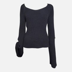 Gucci par Tom Ford, collection automne-hiver 2003 : pull noir en maille côtelée, à une seule épaule et à manches cloche, orné d'une boucle en cuir