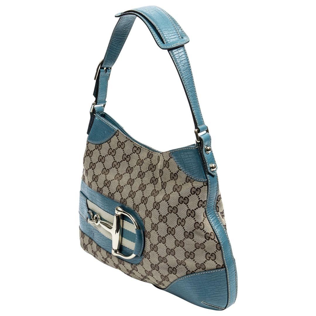 We love the color-way of this Gucci by Tom Ford beauty! Crafted in the signature beige GG monogram canvas, with silver-tone hardware, canvas teal blue leather trimmings, with the iconic horsebit accent to the front face! There is a perfect flat