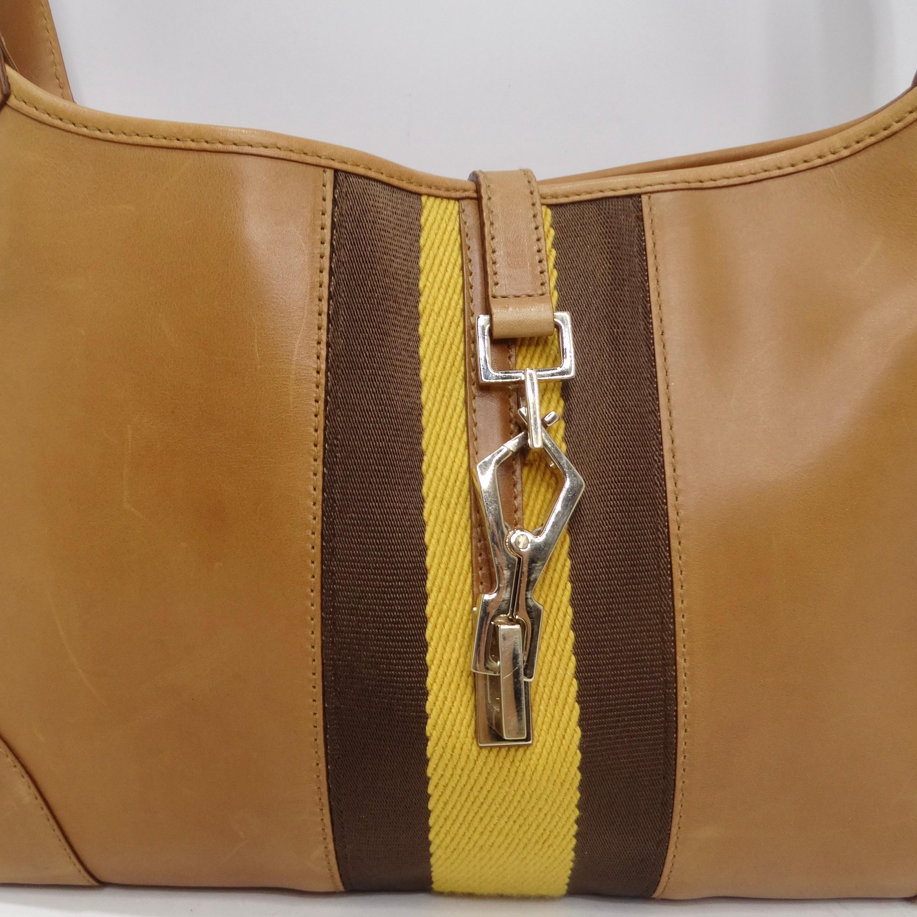 Introducing a handbag that's not just an accessory but a symbol of iconic fashion - the Gucci by Tom Ford Jackie Brown Leather Handbag. This hobo shoulder bag showcases the classic Jackie style in soft camel brown leather, adorned with Gucci stripes