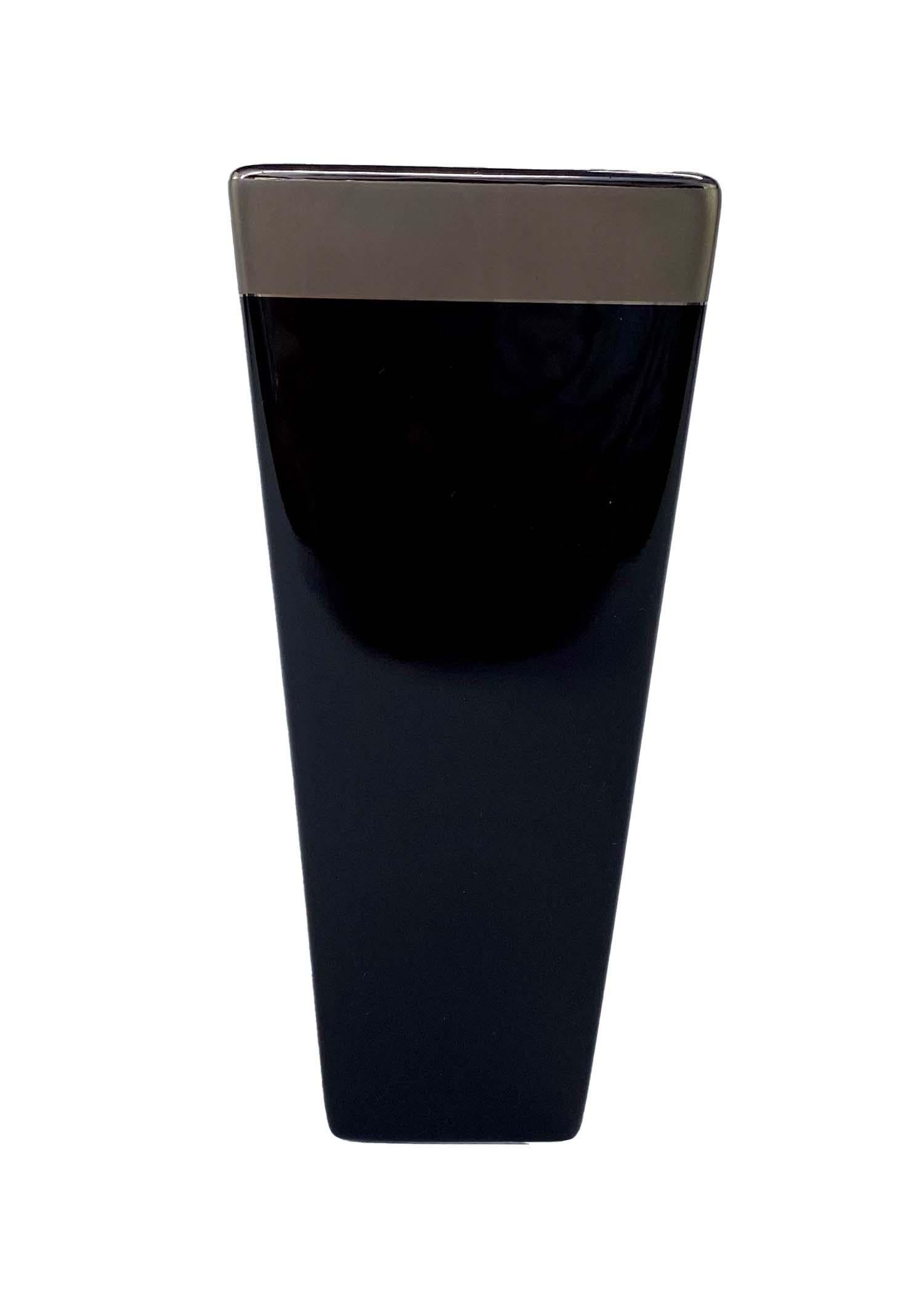 TheRealList presents: a small Gucci bud vase, designed by Tom Ford. This black ceramic vase has a platinum finish and speaks to Tom Ford's simple and chic designs. The small bud vase matches other ceramics from Gucci's home line from the Tom Ford