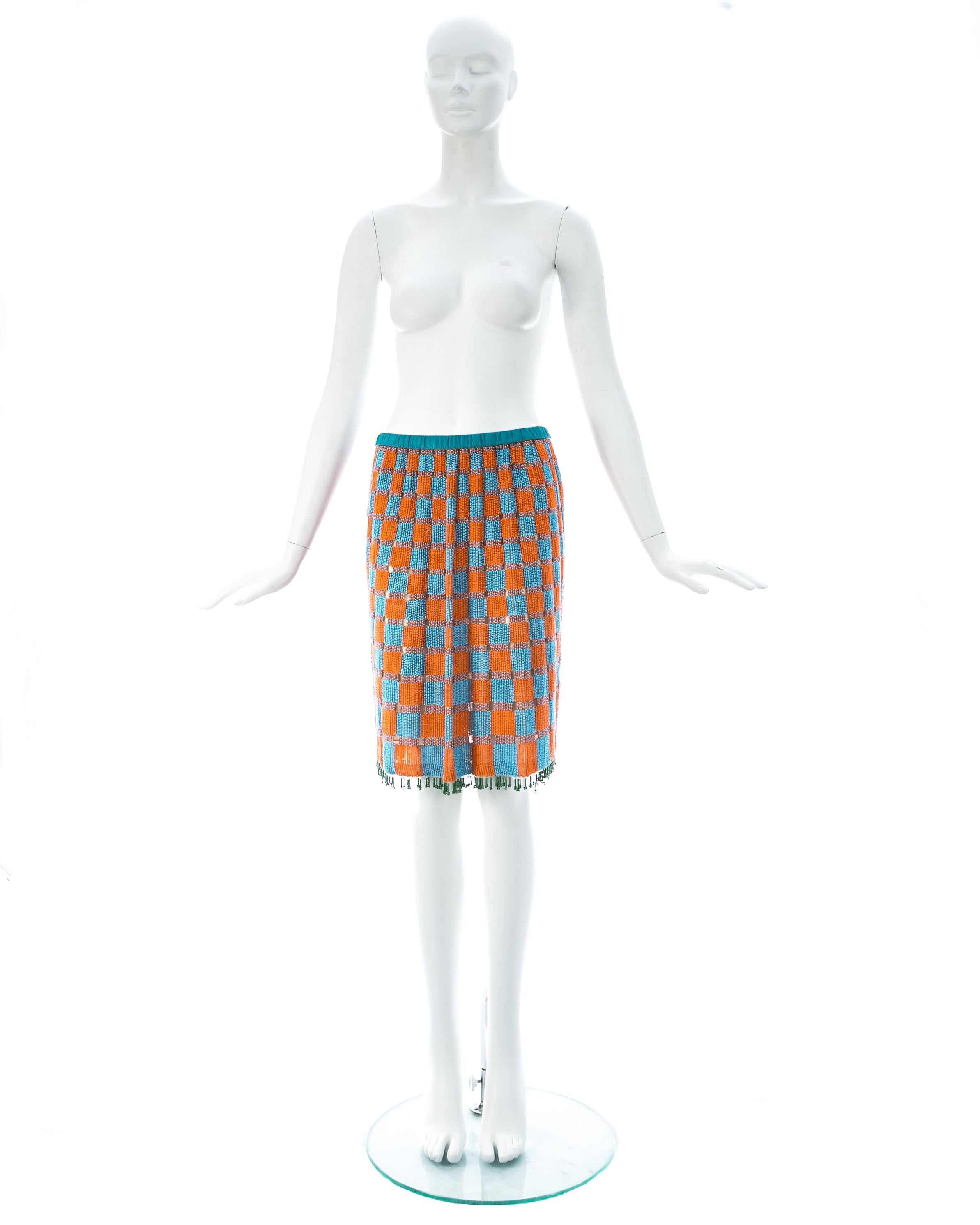 Beaded orange and blue checkered skirt with silk chiffon lining, leather elastic waistband and green beaded fringed trim. 

Spring-Summer 1999